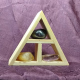 This handcrafted wooden triangle is made of fir and holds three stones and crystals intuitively selected to help you in your intentions for positive workplace energy. 